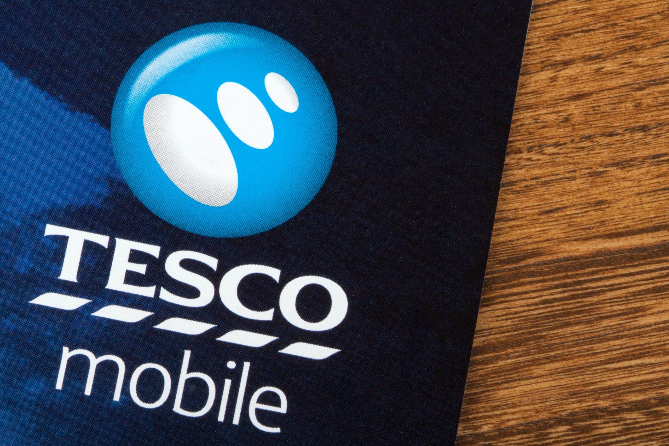 A close-up of a Tesco Mobile brochure or advertisement, showing the company logo and name on a blue background, highlighting digital marketing lessons.