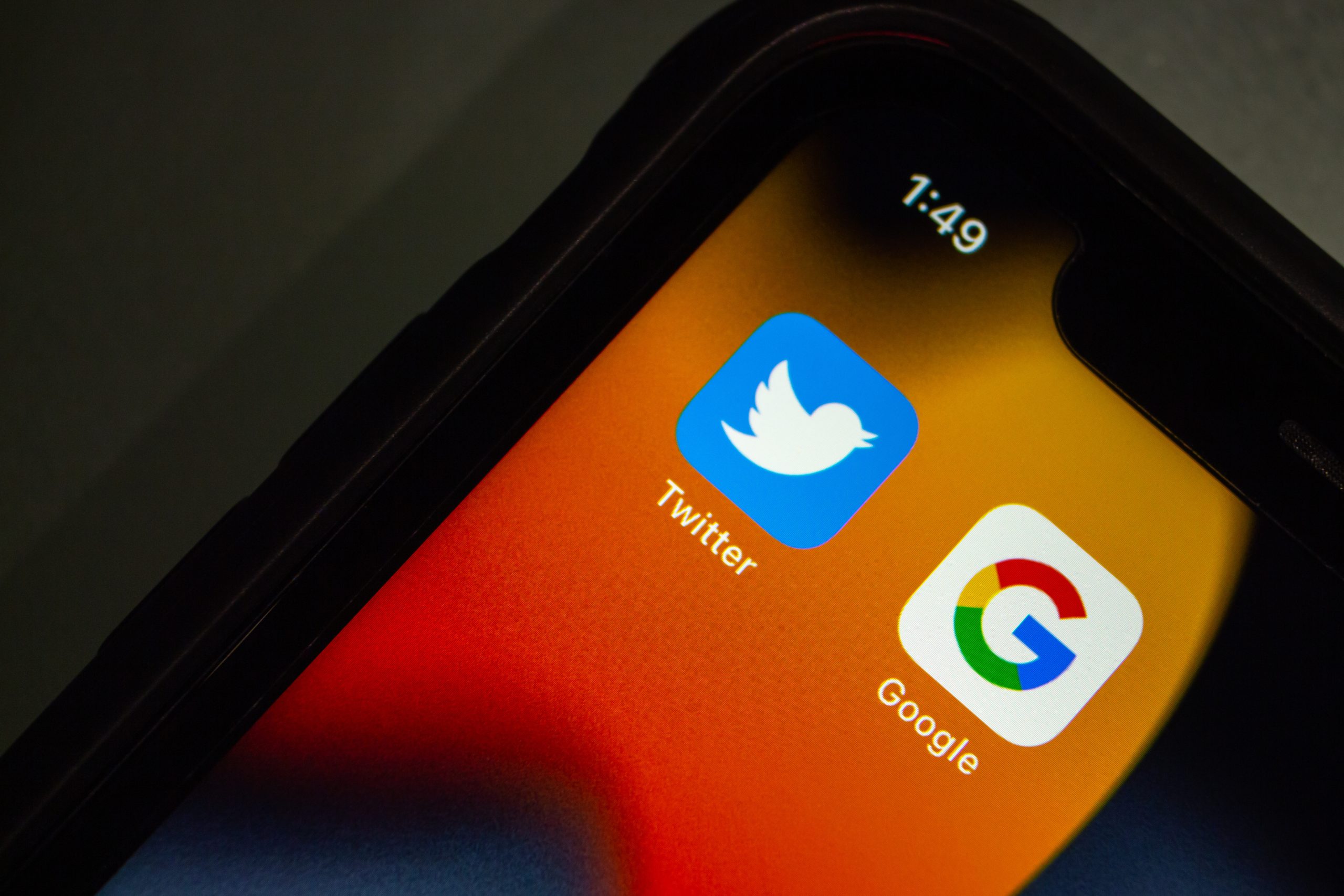 Close-up of a smartphone screen displaying the twitter app icon next to the google app icon, symbolizing the Google-Twitter partnership.