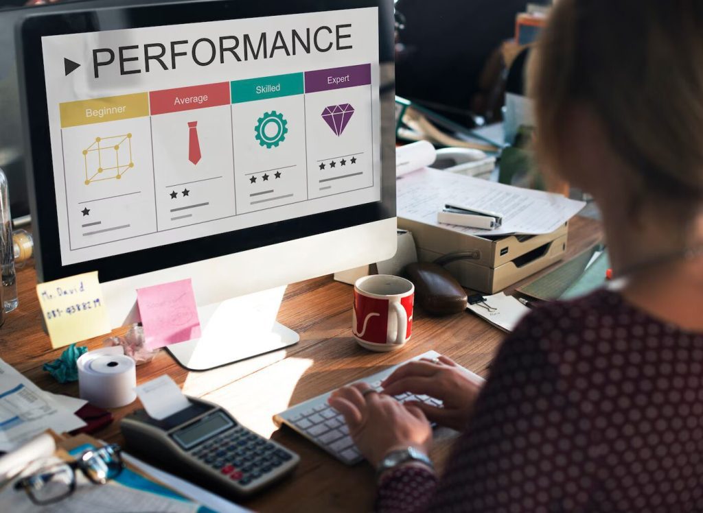 a woman looking at a computer screen with the word performance on it.