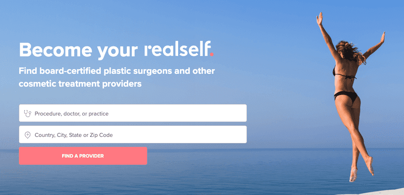 A woman in a black bikini jumps joyfully on a beach against a clear blue sky. On the left, the text reads: "Become your real self. Find board-certified plastic surgeons and other cosmetic treatment providers." Below are search fields and a red "Find a Provider" button.